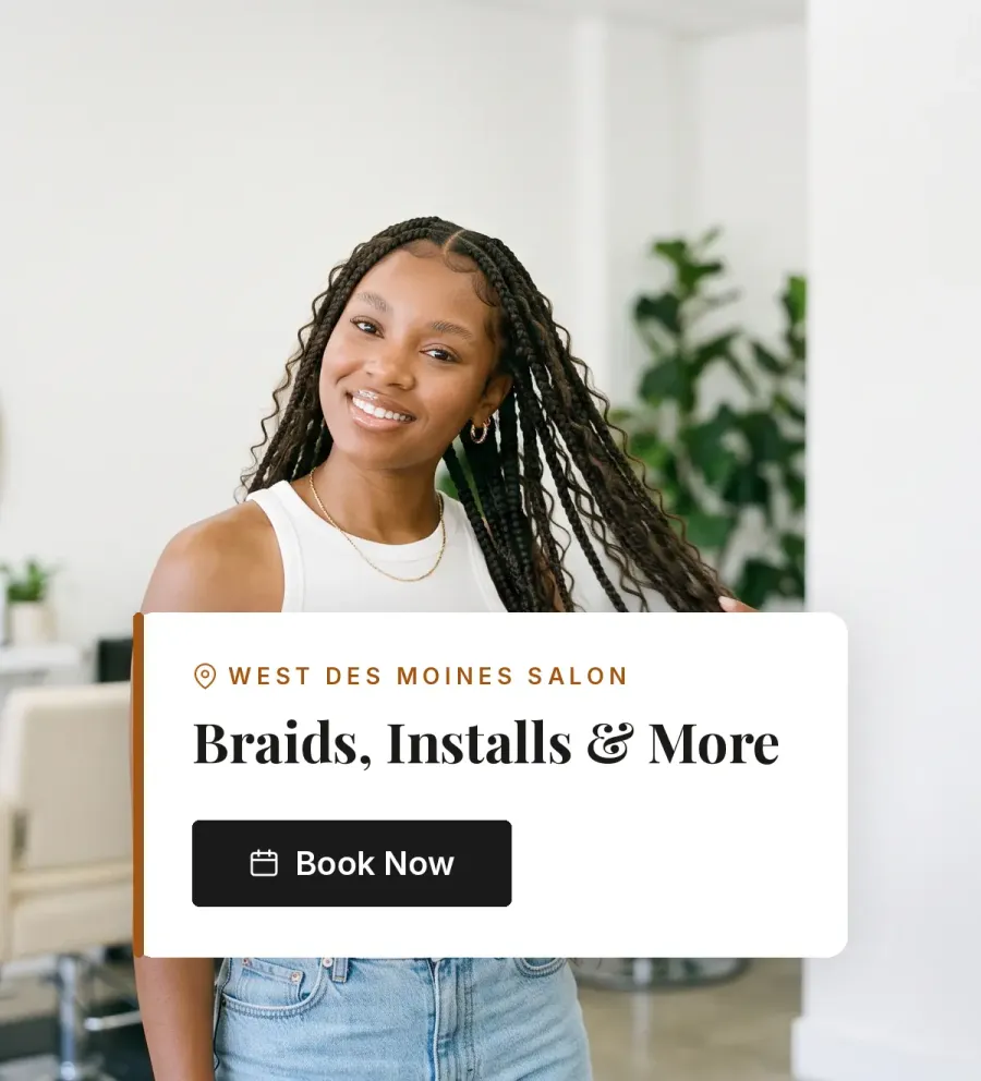 Woman with long boho knotless braids in a bright salon. West Des Moines salon: braids, installs and more. Book Now.